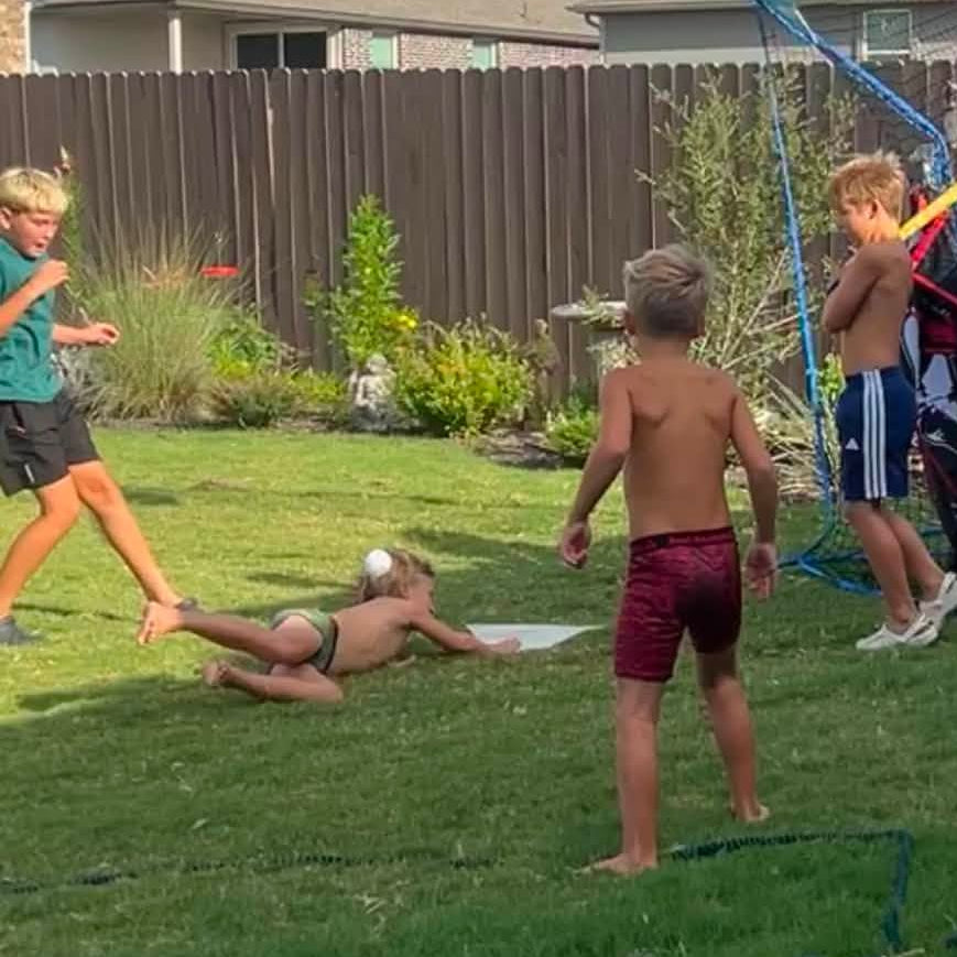 Kids playin wiffle ball in a backyard