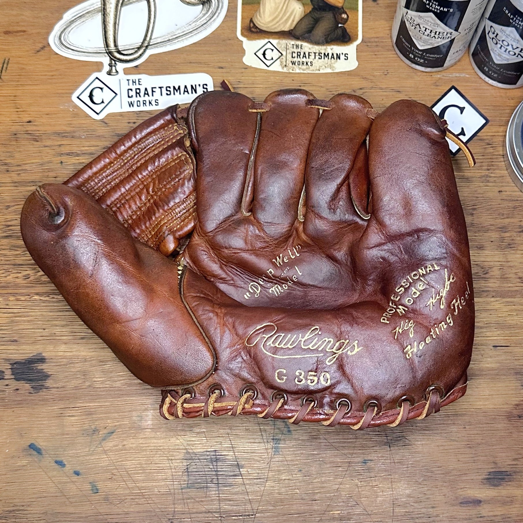 Restored vintage 1940s Rawlings G350 Kirby Hig Higbe leather baseball glove with natural tan laces displayed on a wooden desk