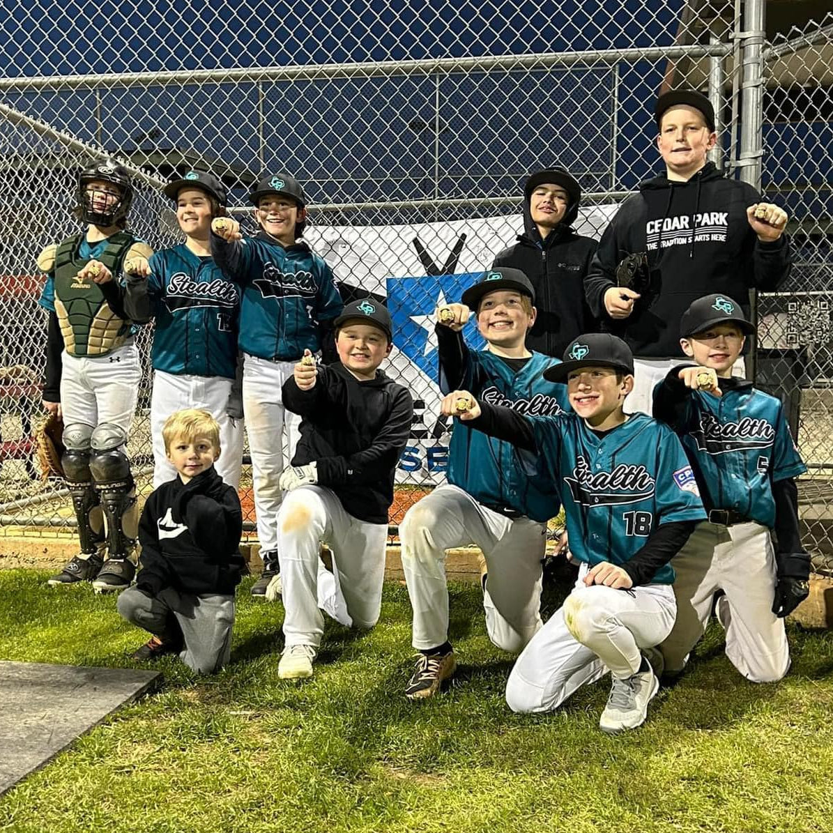 A group of youth baseball teammates celebrating a win.
