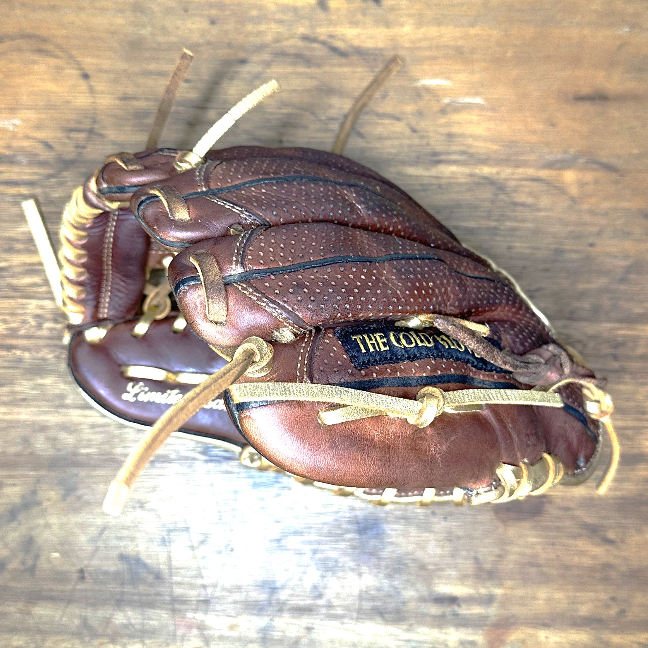 Side view of custom Rawlings Heart of the Hide Sanotan PRO200-4S glove with metallic gold laces, perforated leather back, and modified trap-eze web