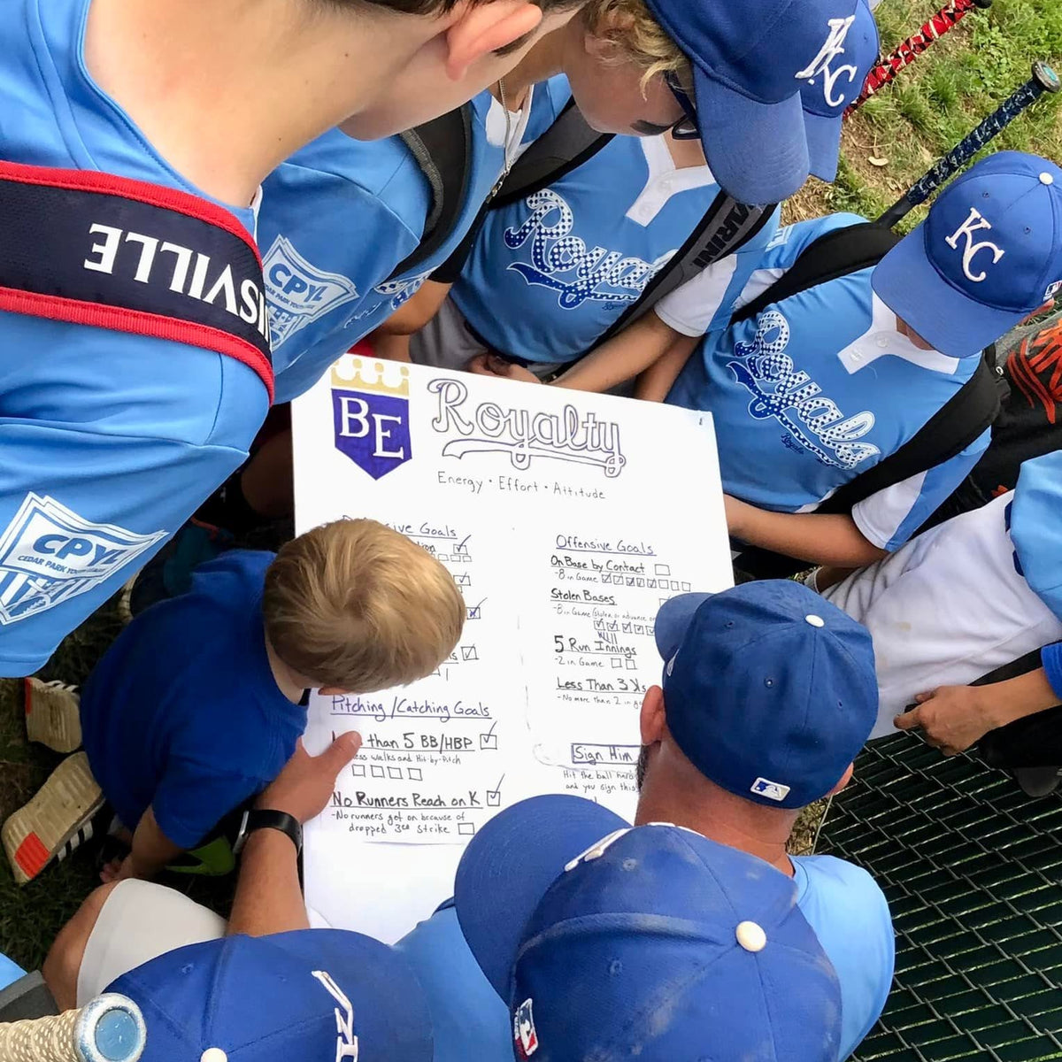 a coach talking to his players after a youth baseball game